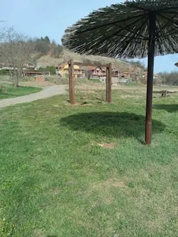 Drvena pergola na travnjaku pored jezera